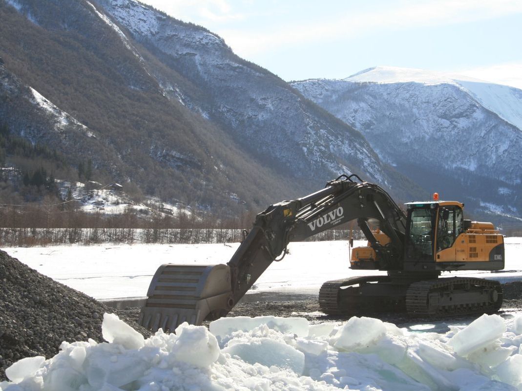 Gravemaskin Volvo EC 380i arbeid om vinteren med fjell i bakgrunnen