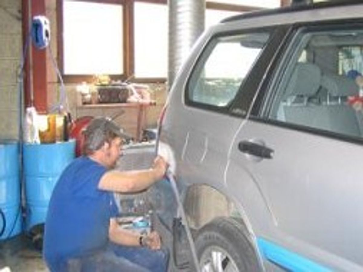 Mann reparerer bilskade på SUV