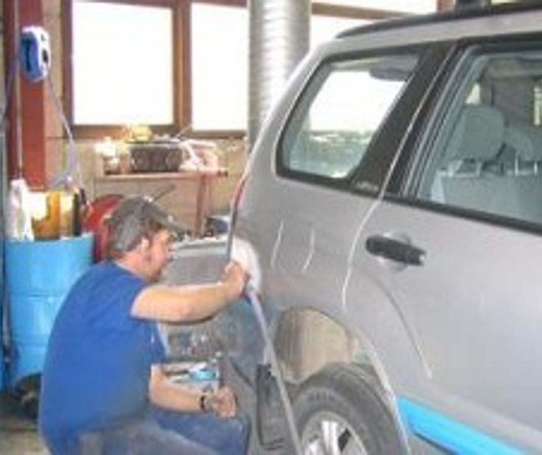 Mann reparerer bilskade på SUV